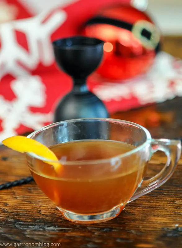 tan cocktail in a teacup, orange zest