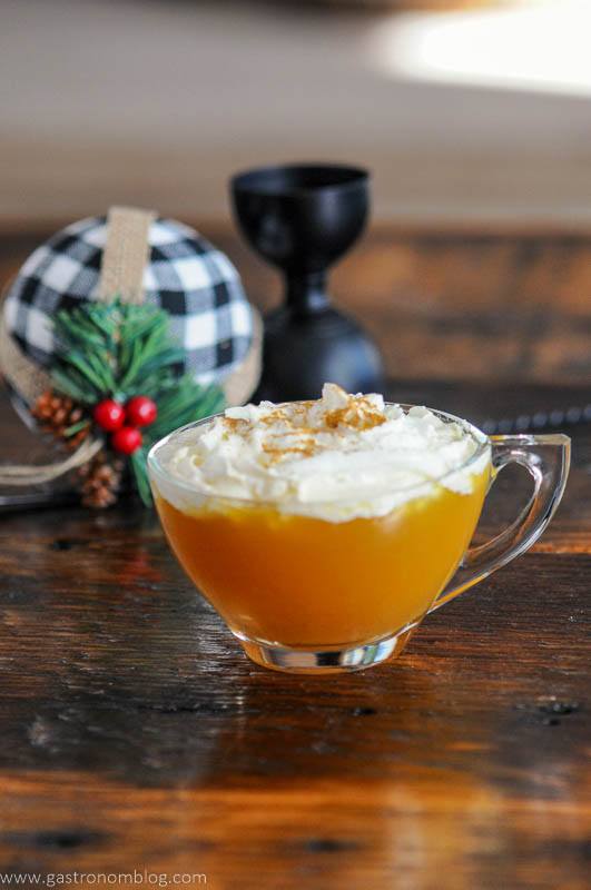 Bourbon Apple Cider Cocktail, in tea cup, topped with whipped cream and cinnamon