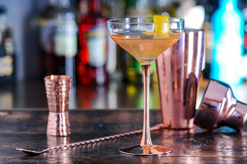 Cocktail in coupe with copper barware behind