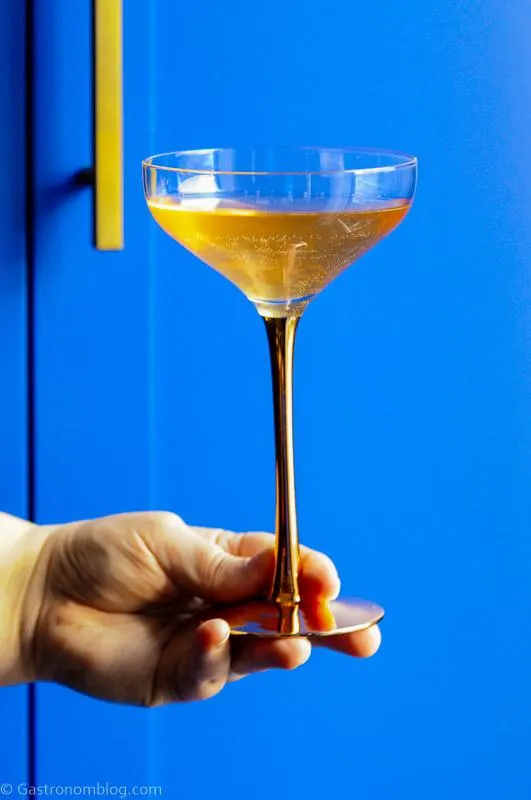 gin and champagne cocktail in coupe, blue background