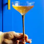 gin and champagne cocktail in coupe, blue background
