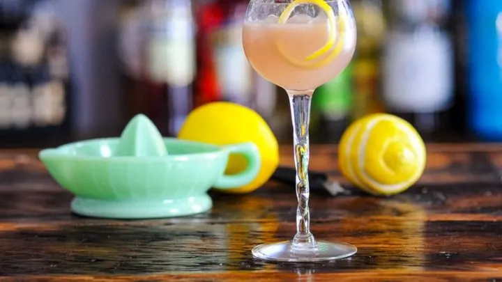 Pink cocktail in coupe with lemon peel