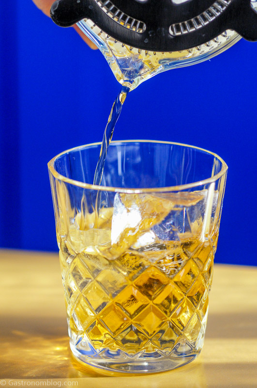Irish whisky being poured into glass from mixing glass