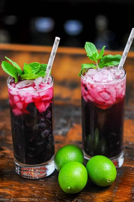 Blueberry Non Alcoholic Mojito in tall glasses, mint and silver dotted straws, limes