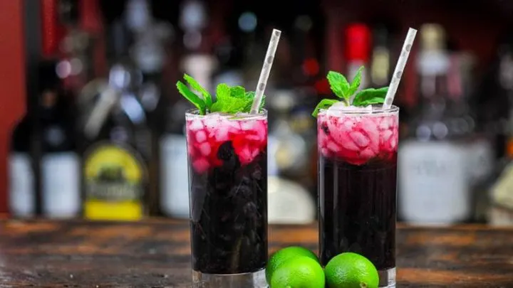 Blueberry Non Alcoholic Mojito, dark red cocktails in tall glasses with mint and straws, limes