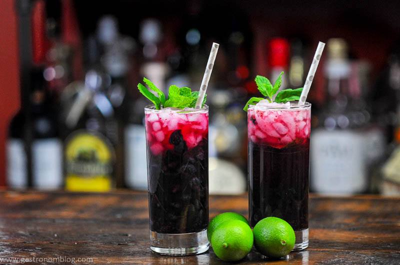 Blueberry Non Alcoholic Mojito, dark red cocktails in tall glasses with mint and silver dotted straws, limes