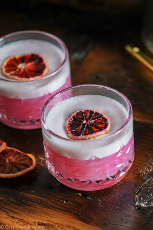 Pink cocktails with white foam in 2 glasses