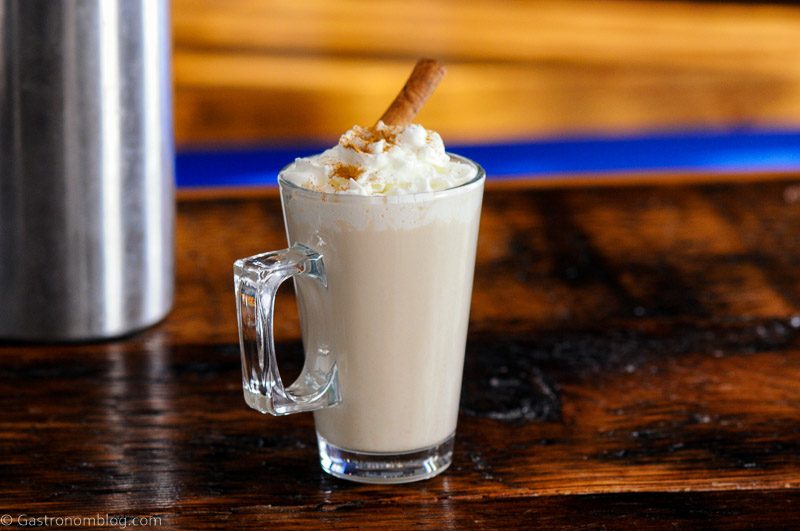 Coffee cocktail in glass mug with whipped cream and cinnamon stick