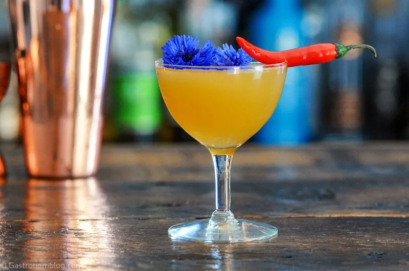 Hot Honey Cocktail in coupe with chili pepper and edible flower