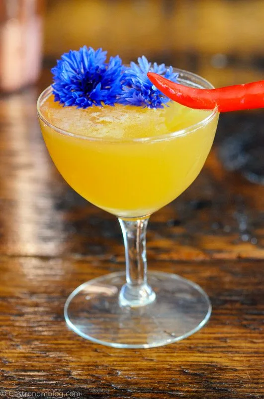 Hot Honey Cocktail in coupe with chili pepper and edible flower