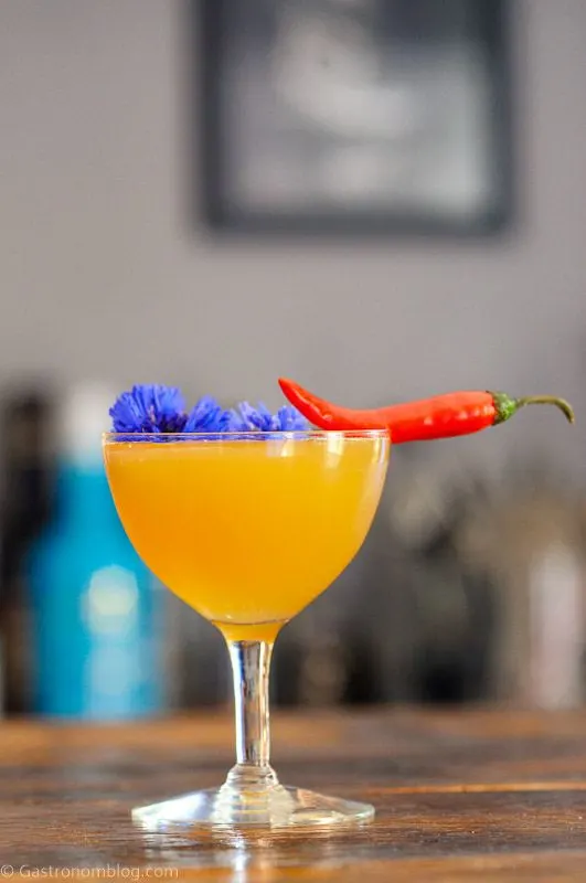 Hot Honey Cocktail in coupe with chili pepper and edible flower