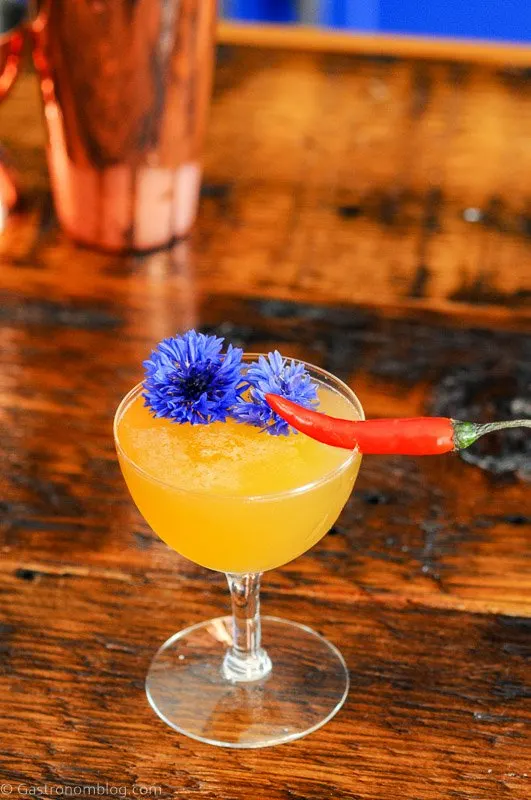 Hot Honey Cocktail in coupe with chili pepper and edible flower