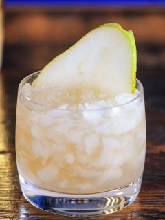 Cocktail in glass with crushed ice, pear slice