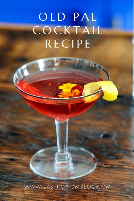 red Old Pal cocktail recipe in coupe with edible flowers and lemon peel