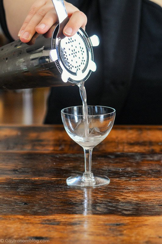 Opaque Vesper Martini Recipe being poured into coupe from mixing glass