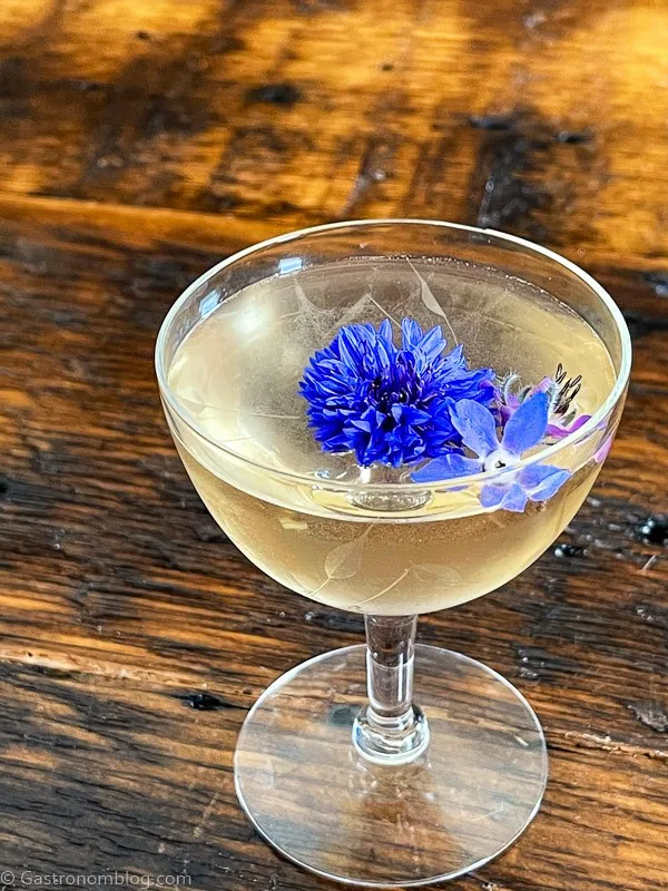 opaque Vesper Martini recipe in coupe with purple flower on top