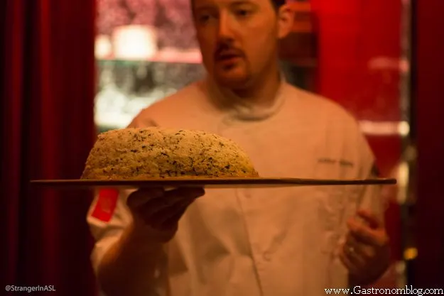 Chef holding board of foie gras baked in salt