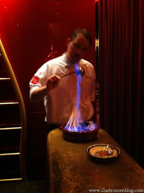 Chef lighting a course on fire for dinner at e by Jose Andres