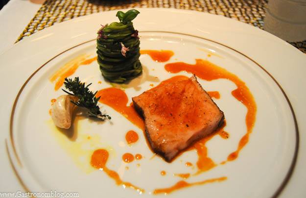 Veal chop with green veggie tower and orange sauce on white plate at Robuchon Las Vegas