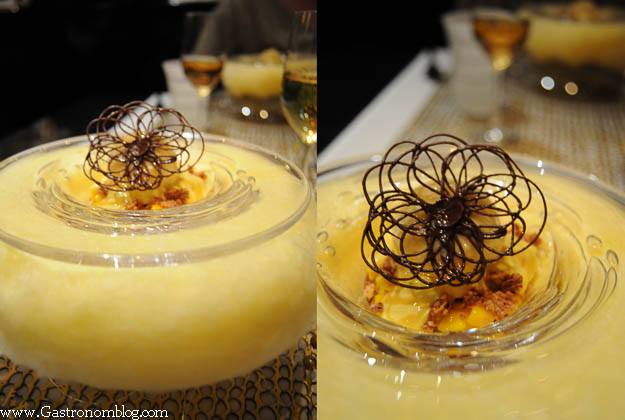 Chocolate and Banana dessert served in glass bowl surrounded by banana cotton candy and topped with chocolate tuille
