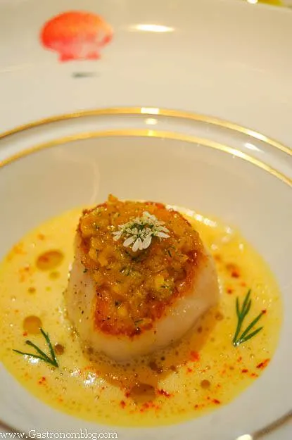Scallop with kumquat sauce in gold rimmed white bowl