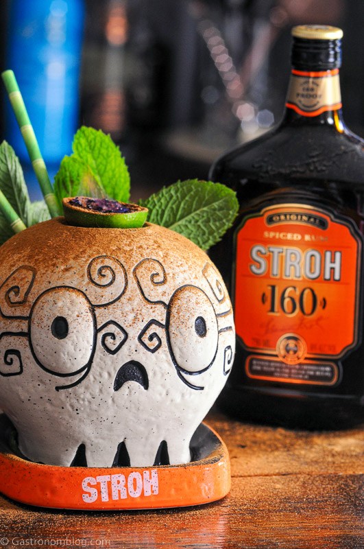 Skull mug with fire from lime slice, Stroh Rum bottle behind