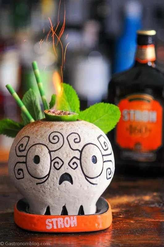 Skull mug with fire from lime slice, Stroh Rum bottle behind