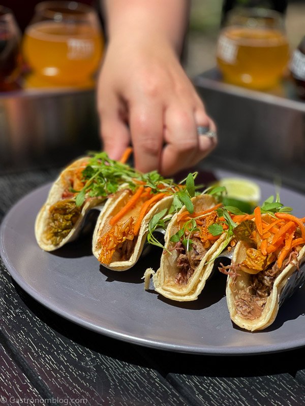 Taco appetizer on stand on a plate, hand touching plate