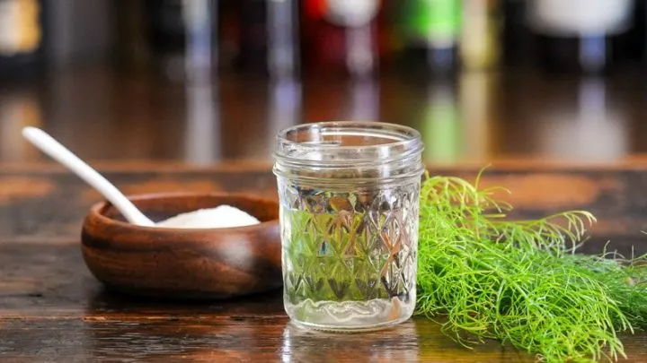 syrup in jar with fennel fronds, wooden bowl of sugar