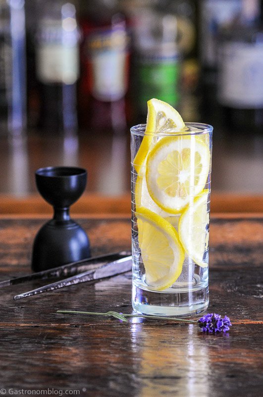 Tall glass lined with lemon slices, this Lavender Collins is a great refreshing and bright yellow cocktail!