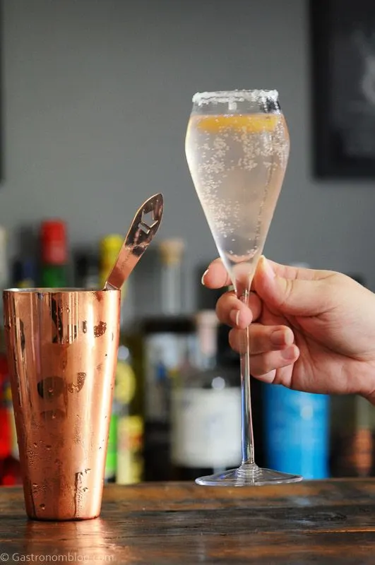 Pink cocktail in tall glass, sugar rim, hand holding glass
