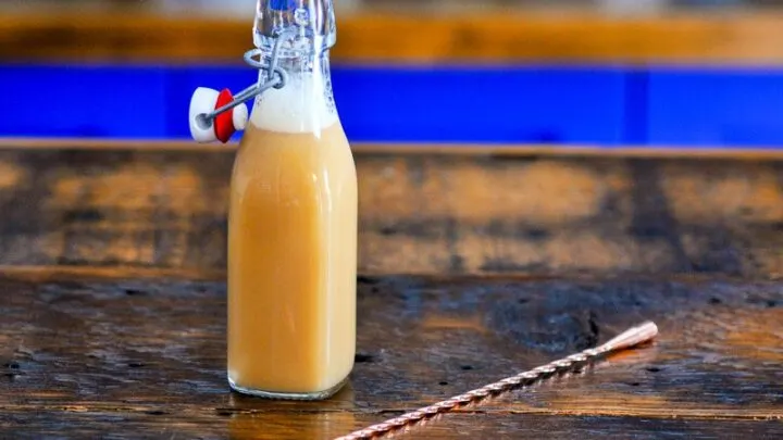 DIY Caramel Vodka, tan liquid in bottle, gold spoon