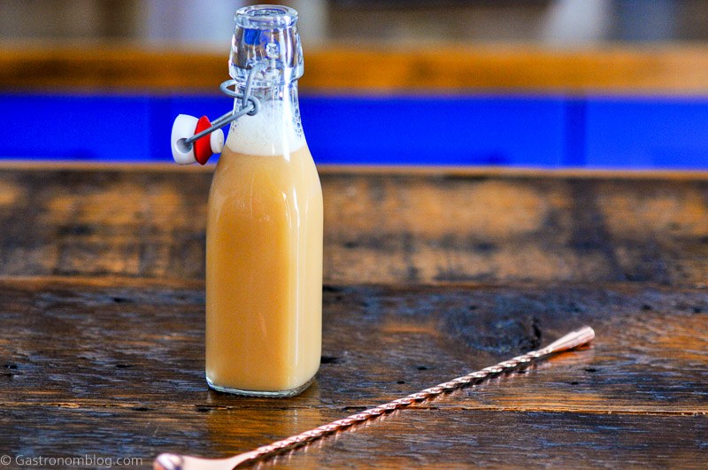 DIY Caramel Vodka, tan liquid in bottle, gold spoon