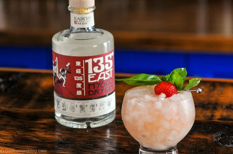 135 East Gin bottle, pink cocktail with strawberry and mint garnish