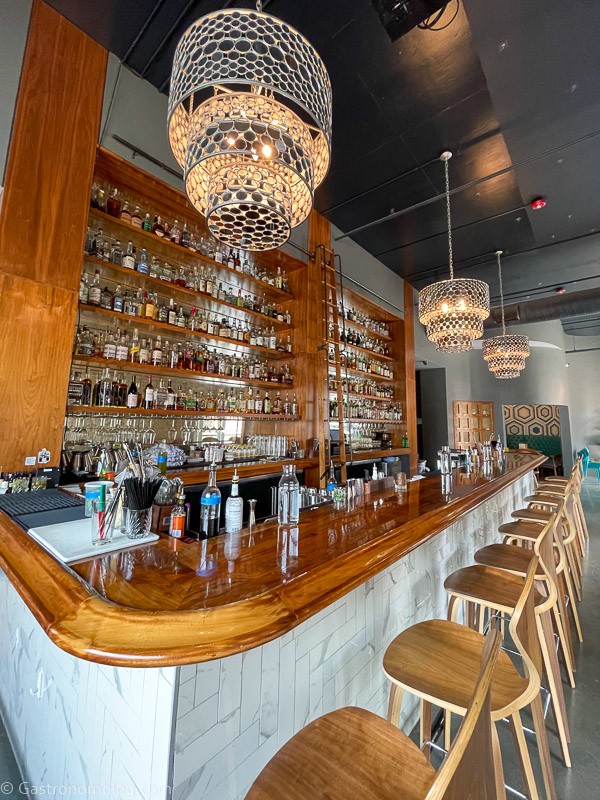 Bar at Julep in Kansas City, wood bar top, white tiles and wooden bar stools