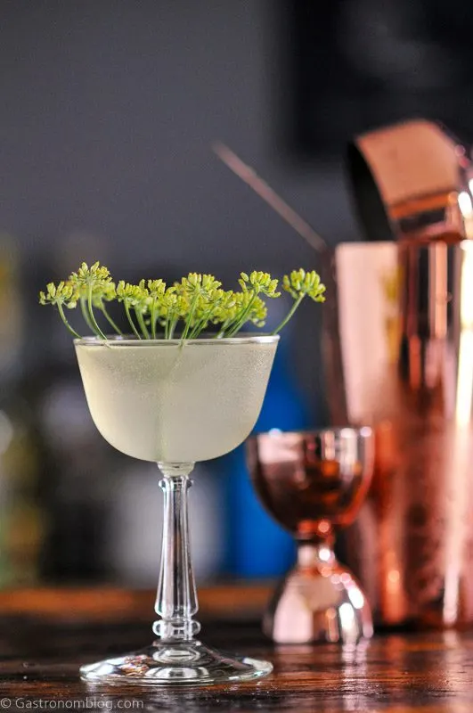 Yellow cocktail in coupe with dill flower, copper barware for Bee's Knees Week