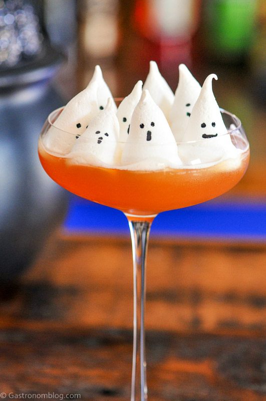 Orange cocktail in coupe with ghost meringues on top