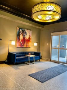 Entryway at Hotel Grinnell, blue couch, artwork and lamps