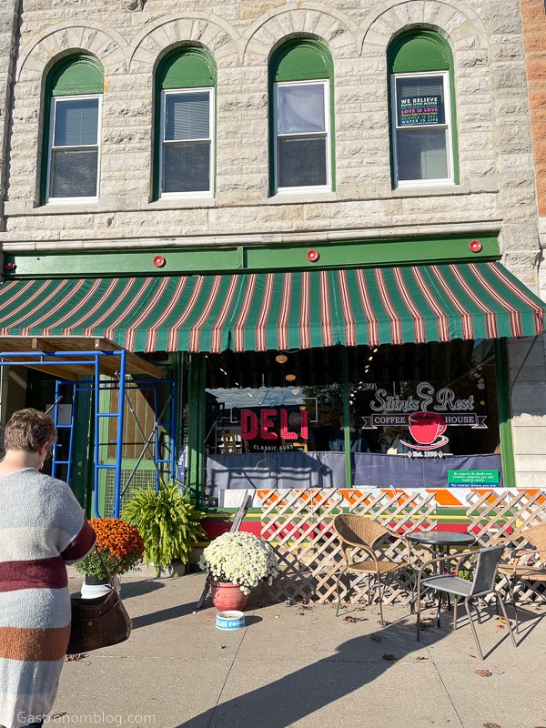 outside picture of Saints Rest Coffee house in Grinnell, Iowa, striped green awning on tan block bulding