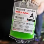 Green cocktail in IV bag to drink out of. Hand holding up