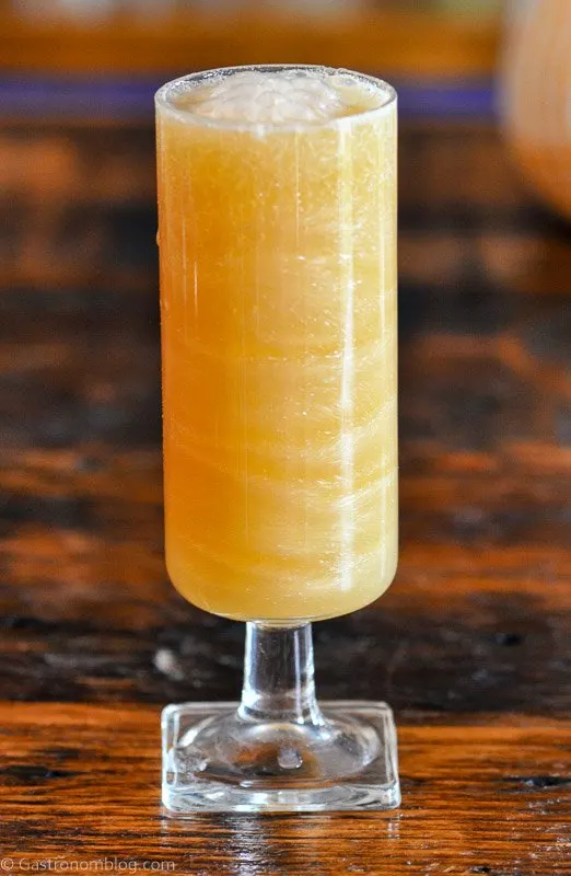 tan Caramel Apple Cider Mimosa cocktail with glitter swirls in tall glass