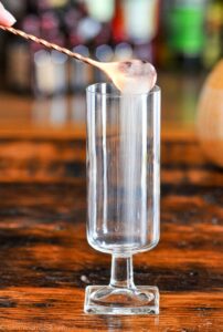 Edible glitter being poured into tall glass
