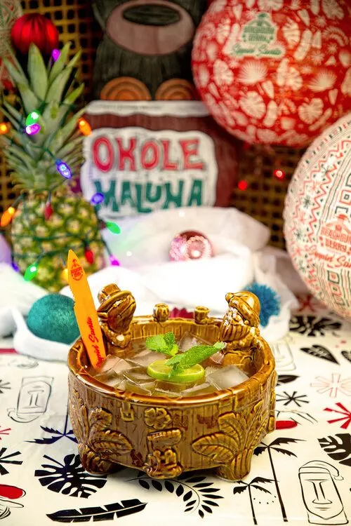 Large Tiki punch bowl with surfers and Christmas Hawaii themed stuff behind