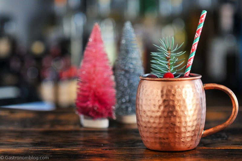 Yule Mule cocktail in copper mug with Christmas straw, cranberries and pine