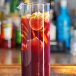 Purple Non Alcoholic Sangria in pitcher with sliced citurs and apples