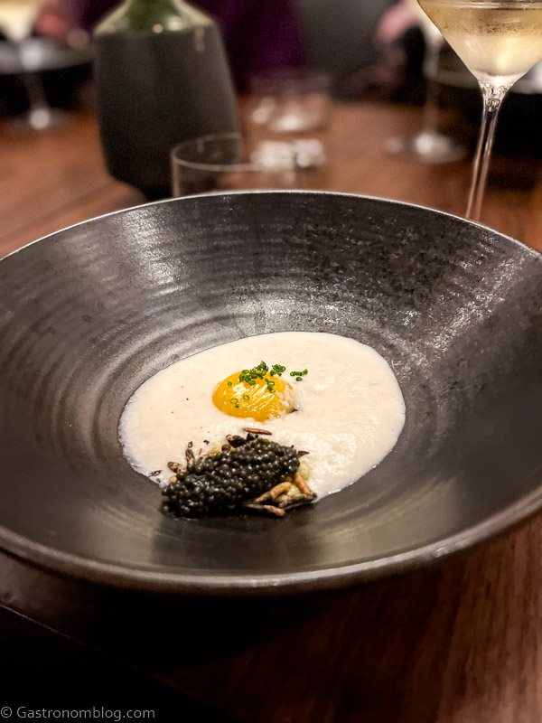 White foam with egg white and black caviar on black plate at The Matheson Healdsburg, California