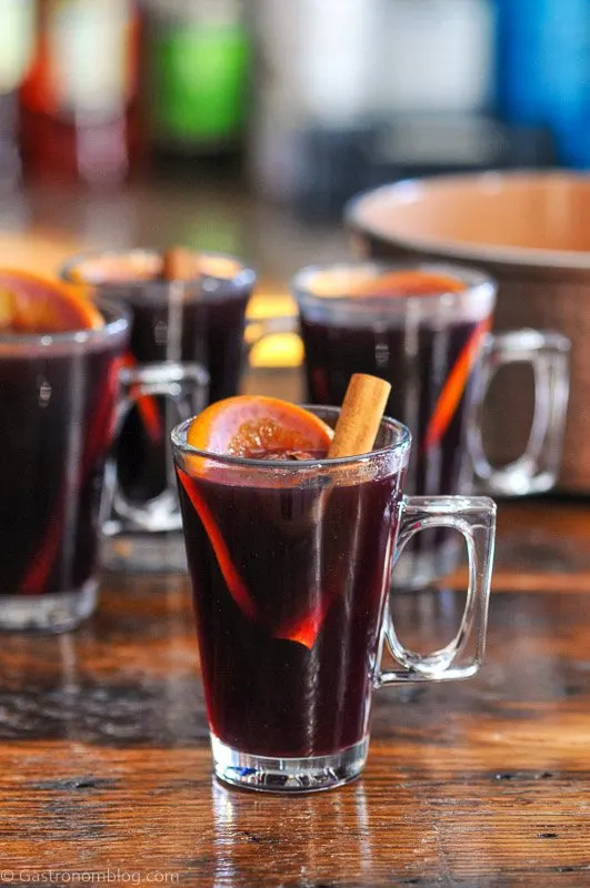Red juice non alcoholic mulled wine in glass mugs with orange slices