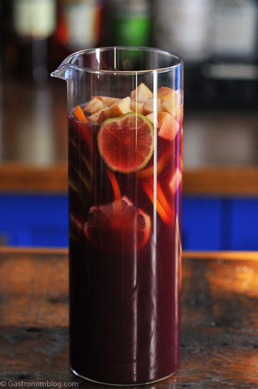 Purple Non Alcoholic Sangria in pitcher with sliced citurs and apples
