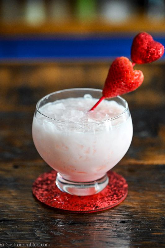 Pink cocktail with strawberry on heart pick, this Strawberry Vodka Cocktail