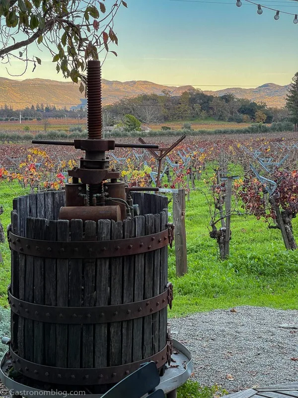 Wine press in front of vineyards
